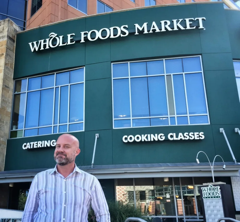 Angus Nelson in front of the Whole Foods Market headquarters in Austin, above the store